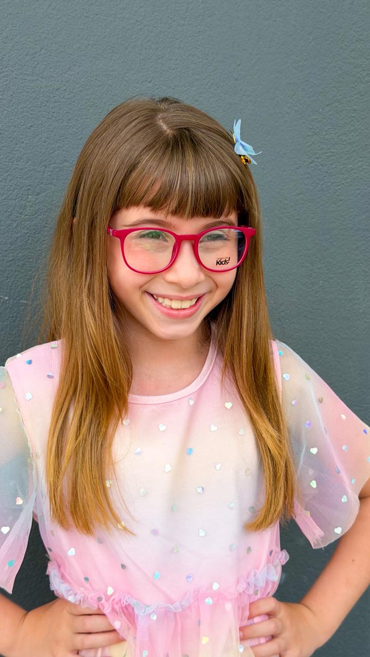 Menina usando óculos de grau com armação rosa da Óptica Royalle
